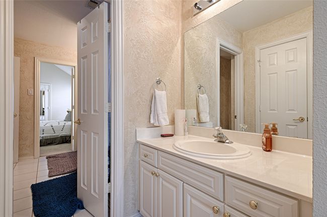 Bathroom featuring a textured wall, vanity, visible vents, and tile patterned floors | Image 18