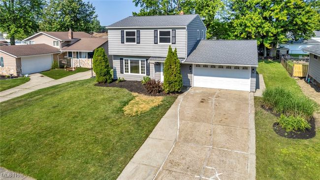 View of front of house with a shingled roof, concrete driveway, and a garage | Image 6