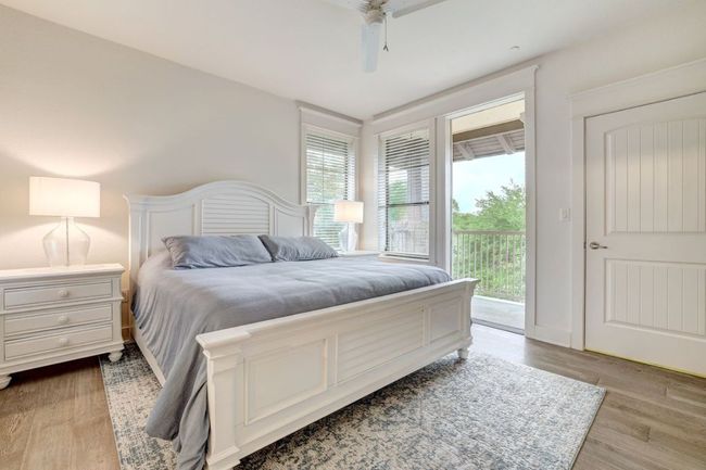 Bedroom featuring access to exterior, light wood-type flooring, and ceiling fan | Image 15
