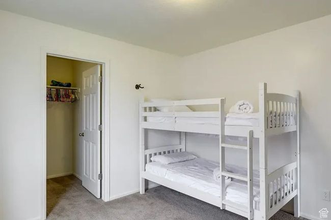 Carpeted bedroom featuring a spacious closet and baseboards | Image 15
