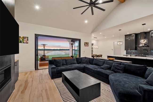 Living area featuring high vaulted ceiling, ceiling fan, light wood-style floors, and recessed lighting | Image 6