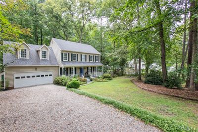 Colonial-style house with a garage, a porch, and a front lawn | Image 2