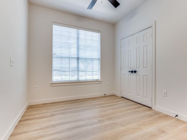 Unfurnished bedroom with light wood finished floors, ceiling fan, and a closet | Image 20