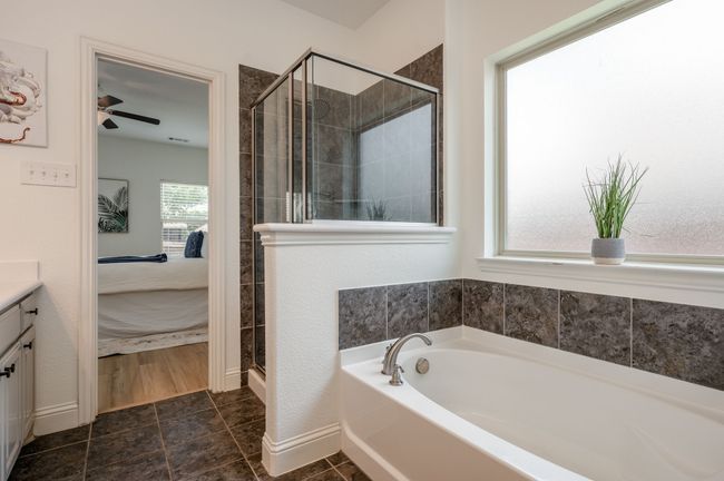 Full bathroom with connected bathroom, a garden tub, a stall shower, vanity, and a ceiling fan | Image 15