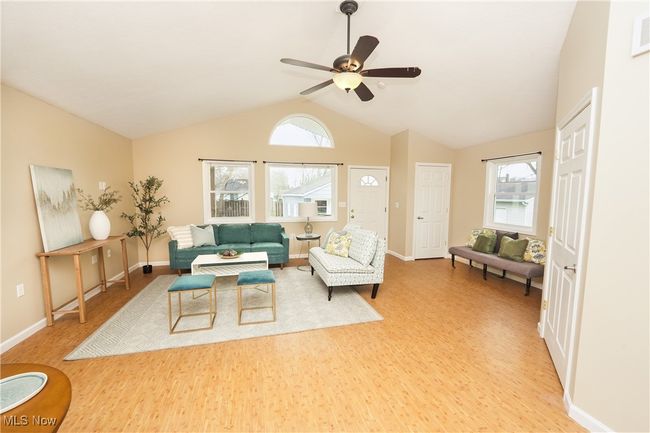 Living room with light wood-style floors, a wealth of natural light, baseboards, and ceiling fan | Image 7