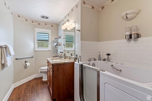 Full bathroom with vanity, toilet, a garden tub, wood finished floors, and baseboards | Image 21