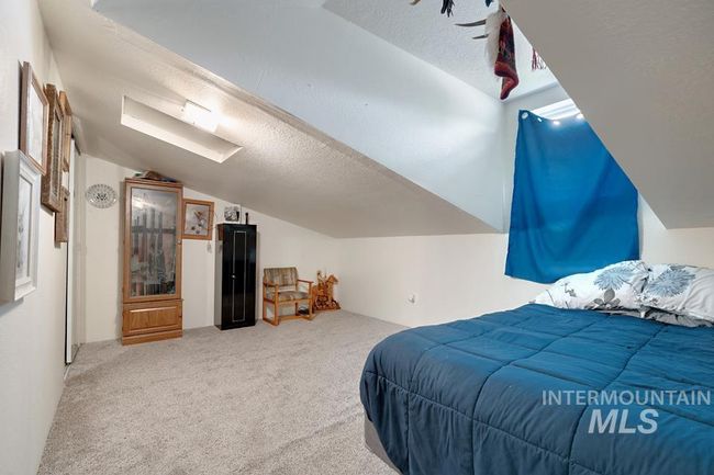 Carpeted bedroom featuring vaulted ceiling and a textured ceiling | Image 27