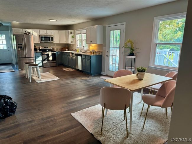Dining area with dark wood-style flooring, a textured ceiling, and recessed lighting | Image 4