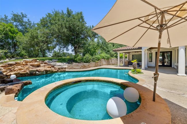 View of pool with french doors, a patio area, a pool with connected hot tub, and fence | Image 38