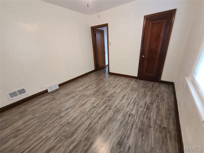 Unfurnished room with wood finished floors and baseboards | Image 8