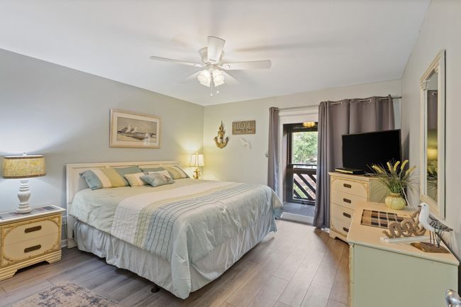 Bedroom featuring a ceiling fan, wood finished floors, and access to exterior | Image 24