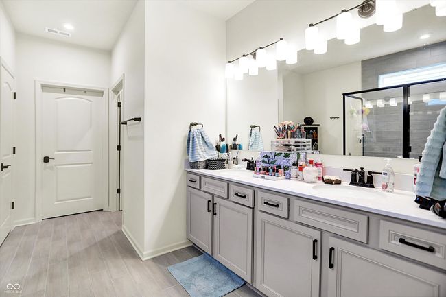 Another example of beautiful choices in this Primary bathroom with double vanity, a stall shower, and wood look finished floors | Image 15