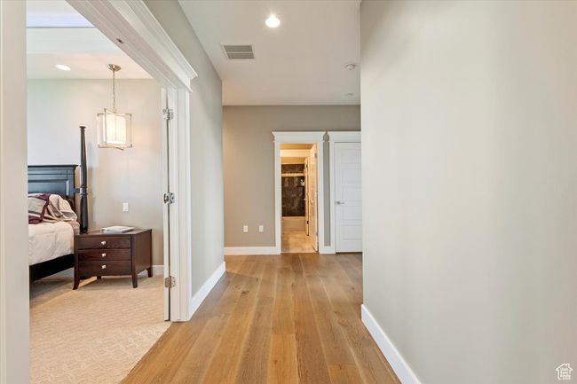 Hallway with light wood-style flooring, baseboards, recessed lighting, and a chandelier | Image 20
