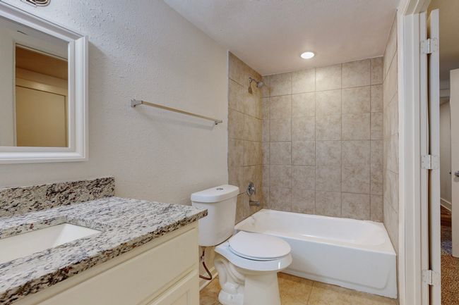Full bathroom with vanity, toilet, tiled shower / bath combo, and tile patterned flooring | Image 21