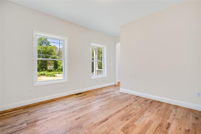 Unfurnished living room featuring visible vents, light wood-style flooring, ceiling fan, and a decorative wall | Image 6
