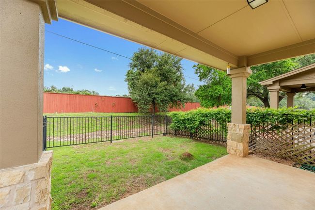 Fenced backyard with a patio | Image 26
