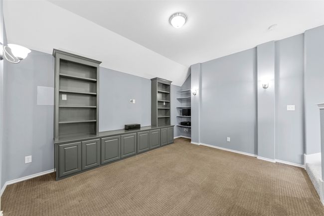 Unfurnished living room with baseboards, light carpet, and lofted ceiling | Image 24