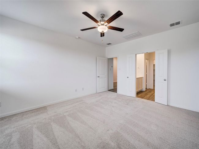 Unfurnished bedroom featuring carpet, baseboards, ensuite bath, and ceiling fan | Image 36