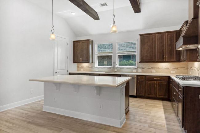 Kitchen with visible vents, a sink, appliances with stainless steel finishes, light countertops, and custom exhaust hood | Image 16