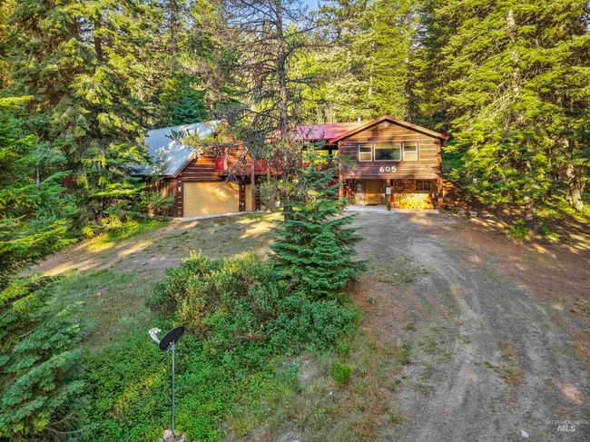 Chalet / cabin with driveway, a wooded view, a metal roof, and a carport | Image 20