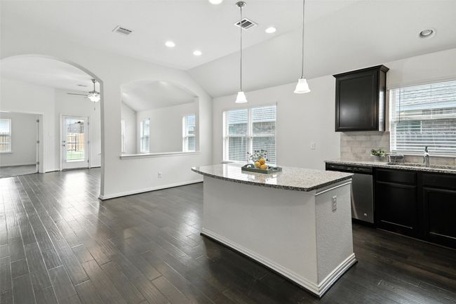Kitchen with stainless steel dishwasher, lofted ceiling, dark wood-style flooring, a ceiling fan, and recessed lighting | Image 10