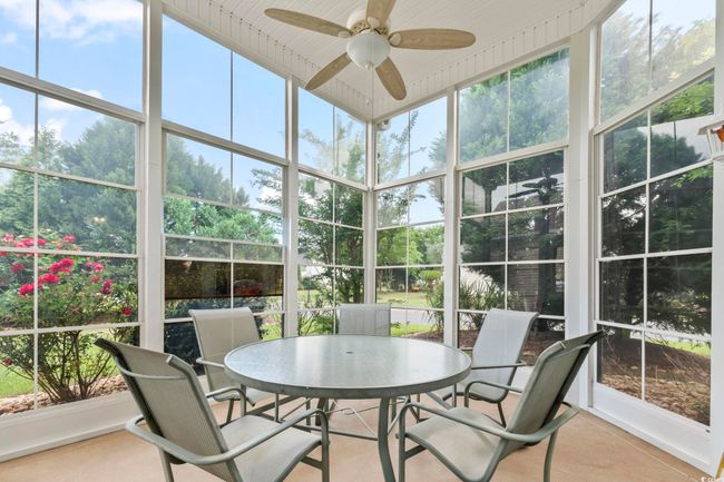 Sunroom / solarium featuring outdoor dining space, ceiling fan, and plenty of natural light | Image 22