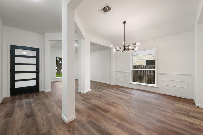 Foyer entrance with a chandelier, wood finished floors, and a wainscoted wall | Image 5