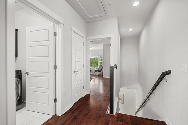 At the top of the stairs, a small landing offers easy access to the primary bedroom, two guest bedrooms, and the laundry room | Image 21