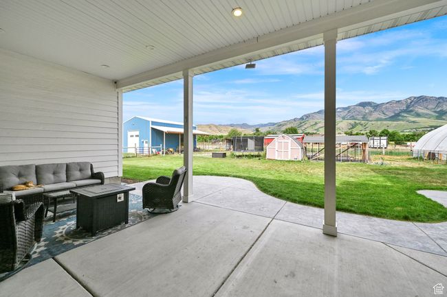 View of patio featuring a storage shed, an outdoor hangout area, and a mountain view | Image 5