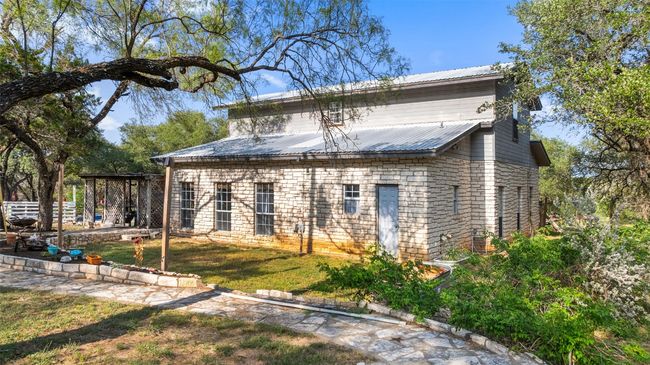 Rear view of house featuring metal roof and a yard | Image 8