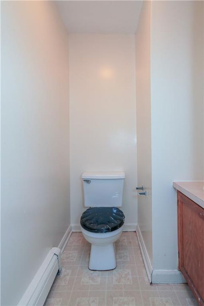 Bathroom featuring vanity, baseboard heating, toilet, and baseboards | Image 7