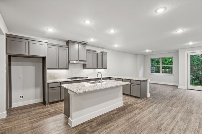 Kitchen with gray cabinets, tasteful backsplash, a peninsula, wood finished floors, and recessed lighting | Image 9