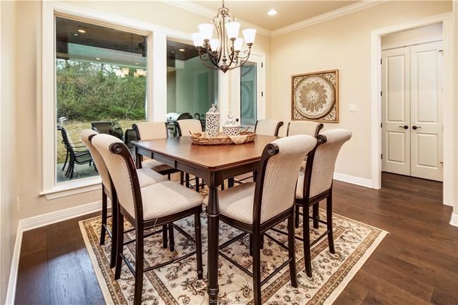 Dining space featuring baseboards, dark wood-style flooring, crown molding, and an inviting chandelier | Image 14