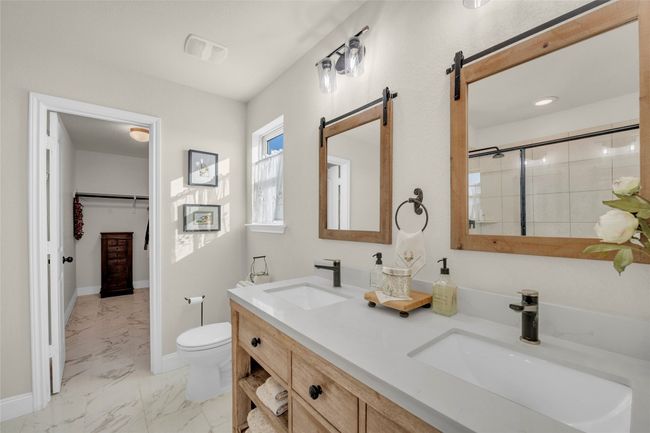 Full bathroom with a double vanity sink, toilet, marble finish floor, and a walk-in shower | Image 21