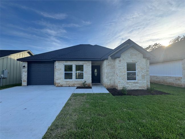 Single story home with stone siding, concrete driveway, and roof with shingles | Image 26