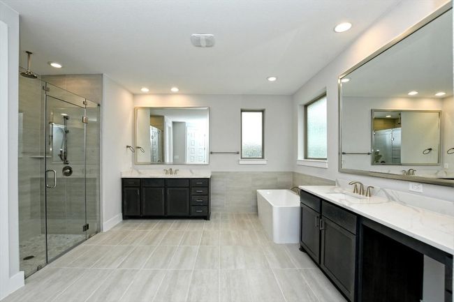 Full bath with two vanities, a sink, a shower stall, and a freestanding tub | Image 18
