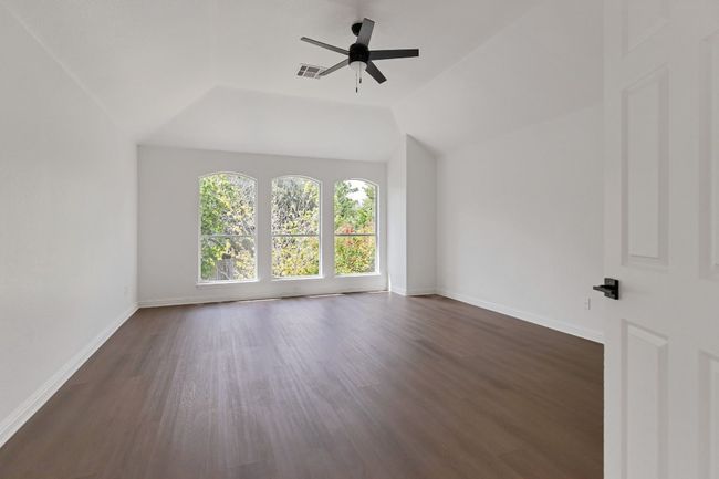 Additional living space with ceiling fan, dark wood-style floors, and vaulted ceiling | Image 23