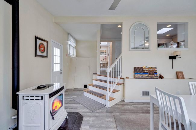 Stairway featuring visible vents, recessed lighting, wood finished floors, ceiling fan, and a wood stove | Image 24