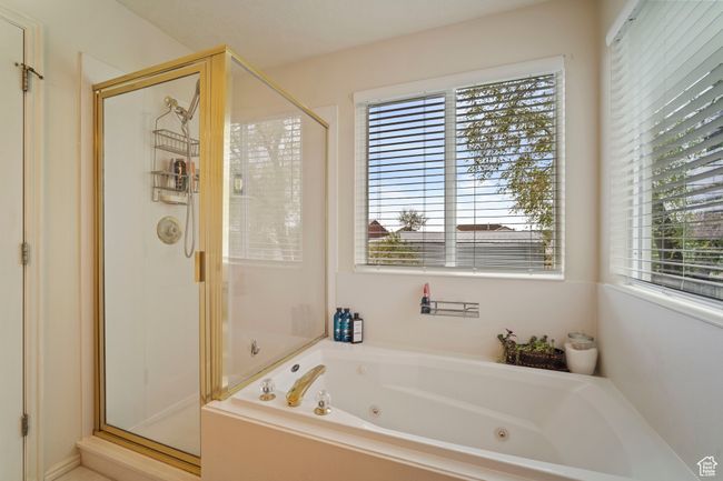 Bathroom featuring a tub with jets and a stall shower | Image 13