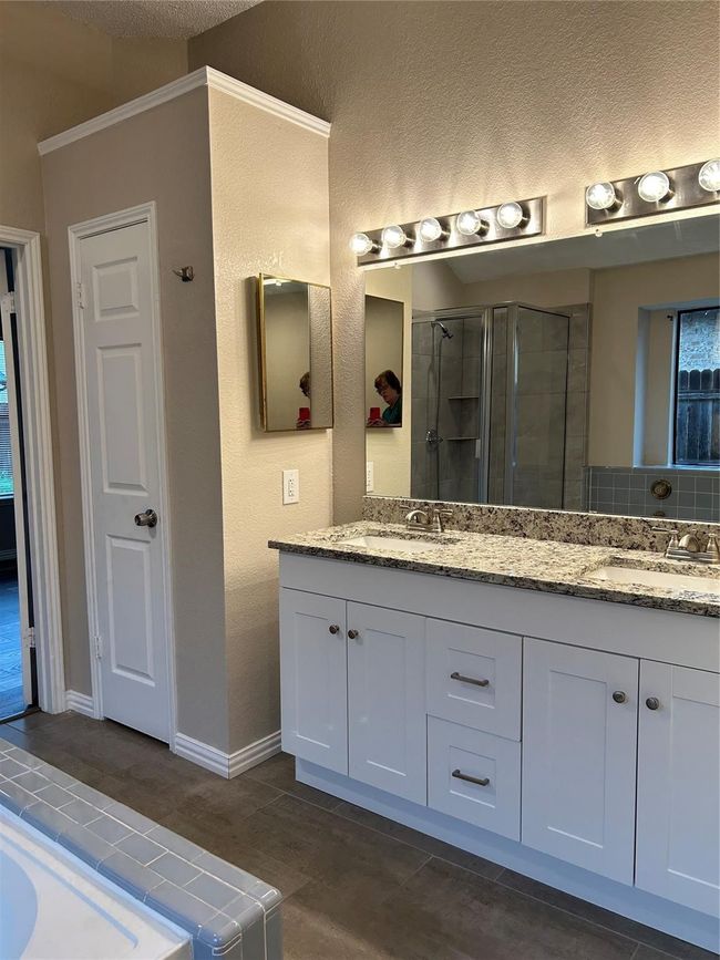 Bathroom with double vanity, a stall shower, a textured ceiling, and a textured wall | Image 12