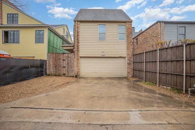 Back of property with fence, a shingled roof, a garage, and concrete driveway | Image 21