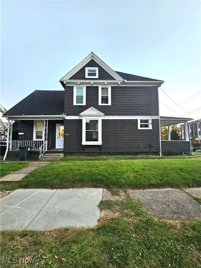 Side view of duplex that sits on a corner lot. Wood siding. Side porch and entrance to botom unit. Also stairs to left going to 2nd unit. | Image 2