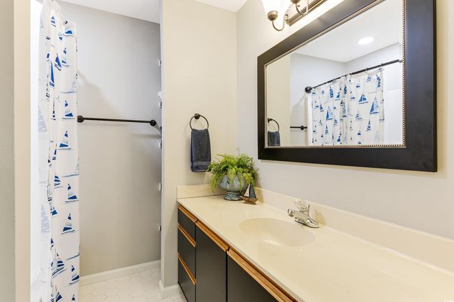Full bathroom with tile patterned floors, vanity, baseboards, and a shower with curtain | Image 24