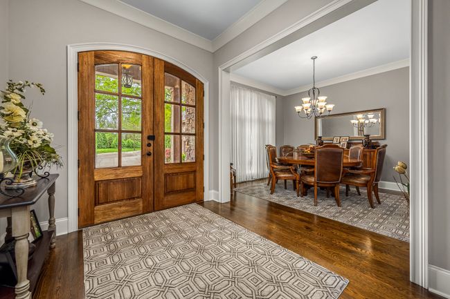 As you step inside, the rich, natural tones of the wood create a warm and inviting atmosphere, seamlessly connecting the entryway to the adjacent dining and family rooms. The open floor plan enhances the sense of space. | Image 30