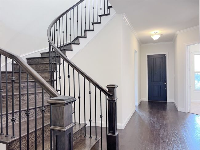 Foyer entrance featuring wood finished floors, stairway, and crown molding | Image 7