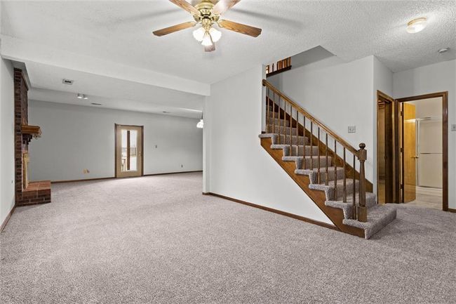Unfurnished living room with carpet, ceiling fan, and a textured ceiling | Image 23