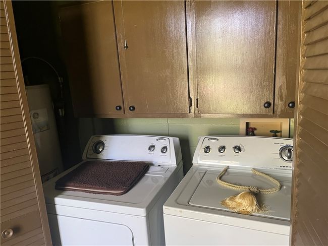 Laundry area with cabinet space and water heater | Image 24