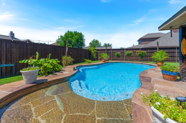 View of swimming pool with a fenced backyard and a patio area | Image 31