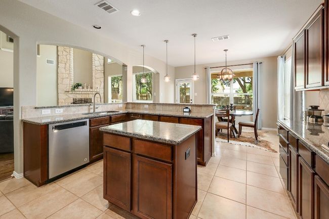 With ample counter space and a large breakfast bar, the kitchen provides a perfect setup for hosting guests or simply enjoying a casual meal while staying connected to the rest of the home | Image 19