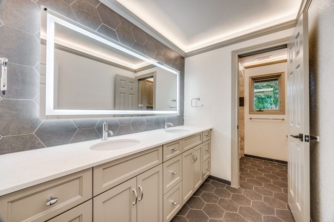 Bathroom with double vanity, tasteful backsplash, and tile patterned flooring | Image 18
